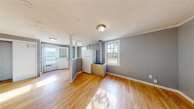 226 Marshall Ave, Cumberland, RI 02864 - unfurnished bedroom with freestanding refrigerator, light wood-style floors, baseboards, and a textured ceiling
