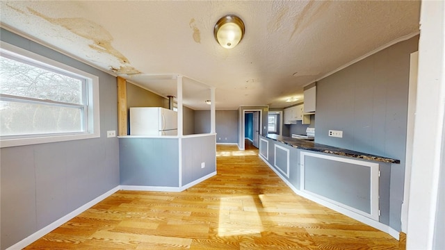 226 Marshall Ave, Cumberland, RI 02864 - kitchen featuring freestanding refrigerator, light wood-style floors, dark countertops, baseboards, and a textured ceiling