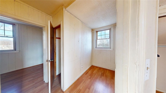 226 Marshall Ave, Cumberland, RI 02864 - corridor featuring light wood-style floors, wood walls, and a textured ceiling