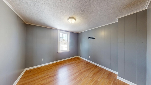 226 Marshall Ave, Cumberland, RI 02864 - spare room featuring light wood-type flooring, ornamental molding, a textured ceiling, and baseboards