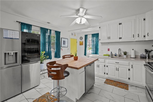 54 Delway Rd, East Providence, RI 02914 - kitchen with stainless steel appliances, wooden counters, a sink, light marble finish floors, and white cabinets
