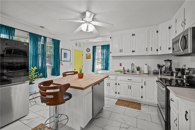 54 Delway Rd, East Providence, RI 02914 - kitchen featuring stainless steel appliances, butcher block countertops, a sink, light marble finish floors, and white cabinets