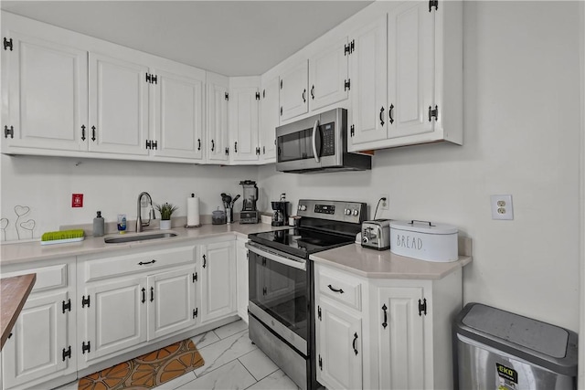 54 Delway Rd, East Providence, RI 02914 - kitchen featuring stainless steel appliances, a sink, light marble finish flooring, white cabinetry, and light countertops