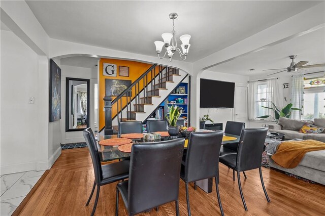 54 Delway Rd, East Providence, RI 02914 - dining room featuring stairs, arched walkways, a chandelier, a ceiling fan, and baseboards