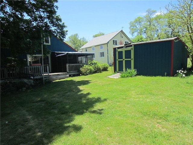 0 Beach Rd, Portsmouth, RI 02871 - view of grassy yard with an outbuilding, a deck, a storage shed, and a sunroom