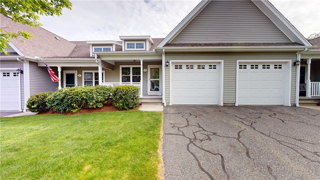 view of front facade with a garage, asphalt driveway, a porch, and a front lawn