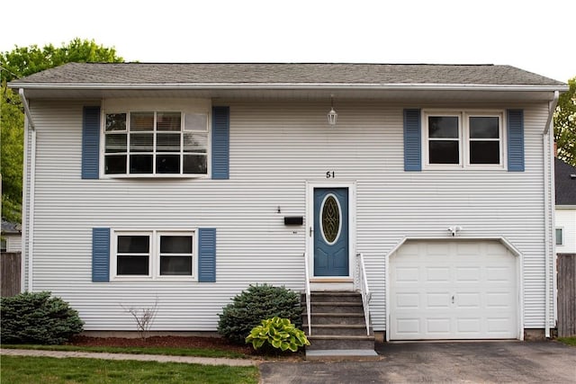 51 Perkins St, Cranston, RI 02910 - raised ranch featuring an attached garage, entry steps, and asphalt driveway