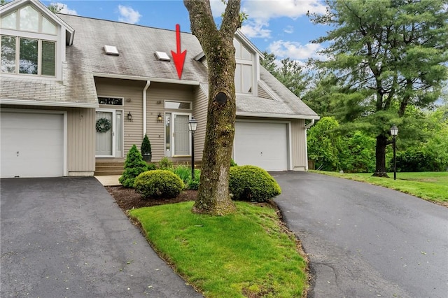 view of front of property with driveway, board and batten siding, and a shingled roof