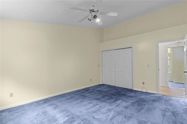 unfurnished bedroom featuring carpet, baseboards, a ceiling fan, and a closet