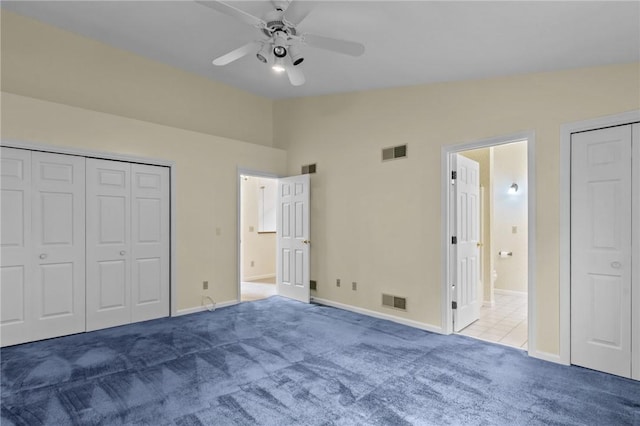 unfurnished bedroom featuring carpet flooring, vaulted ceiling, baseboards, connected bathroom, and a ceiling fan