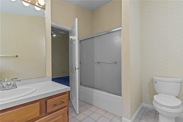 bathroom featuring tile patterned floors, wallpapered walls, toilet, vanity, and shower / bath combination with glass door