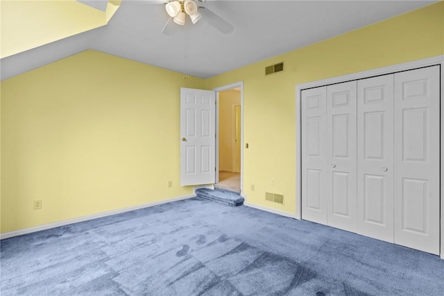 unfurnished bedroom featuring carpet, a closet, vaulted ceiling, baseboards, and ceiling fan