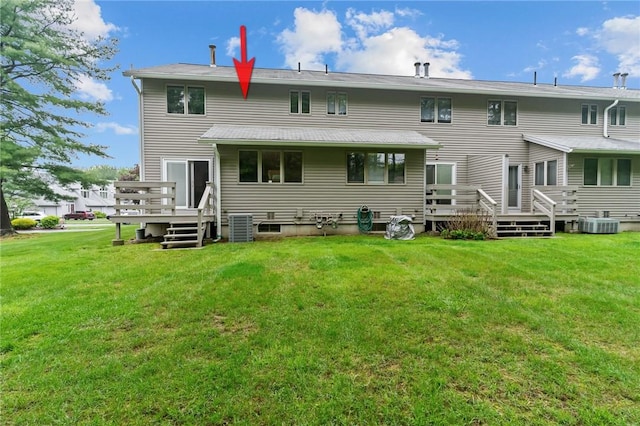 rear view of house with a deck, a yard, and cooling unit