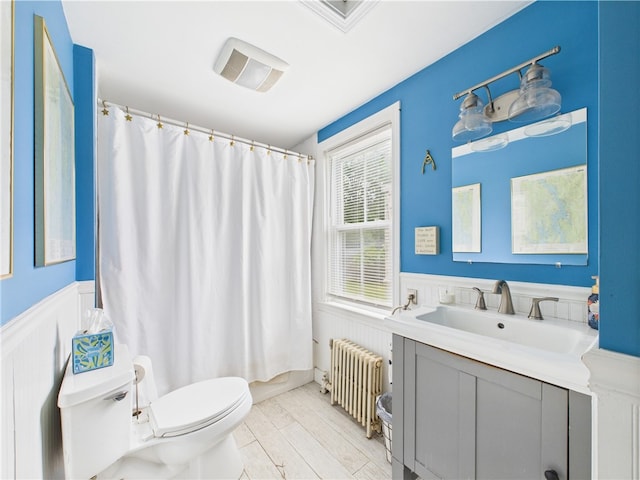 39 Union St, East Greenwich, RI 02818 - bathroom featuring radiator heating unit, toilet, a wainscoted wall, vanity, and curtained shower
