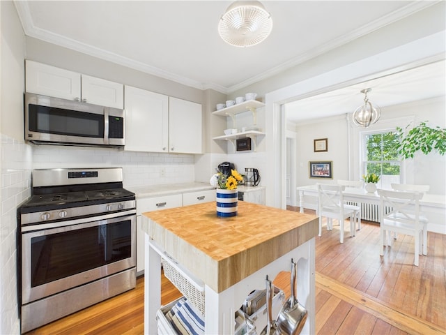 39 Union St, East Greenwich, RI 02818 - kitchen with stainless steel appliances, wood counters, open shelves, white cabinets, and light wood-style flooring
