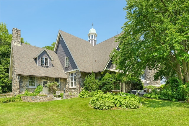 3 Stone Tower Ln, Barrington, RI 02806 - rear view of house featuring stone siding, a chimney, a lawn, and a shingled roof