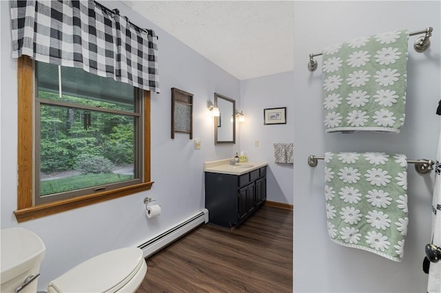 31 Corey Trl, Richmond, RI 02898 - half bath with a baseboard heating unit, toilet, wood finished floors, vanity, and baseboards