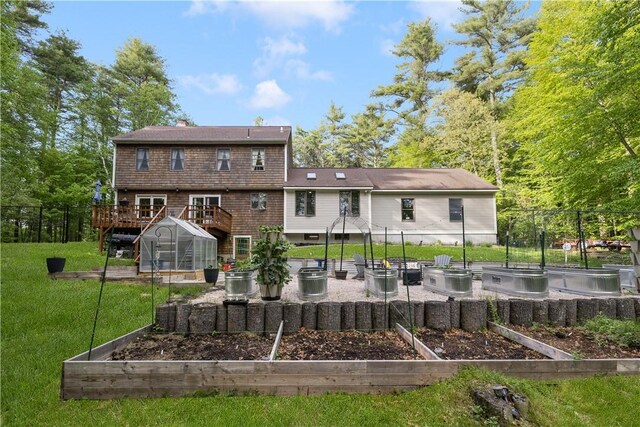 31 Corey Trl, Richmond, RI 02898 - rear view of house featuring a vegetable garden, a greenhouse, a wooden deck, an outdoor structure, and a chimney