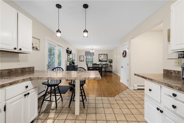 31 Corey Trl, Richmond, RI 02898 - kitchen with baseboard heating, white cabinets, and decorative light fixtures