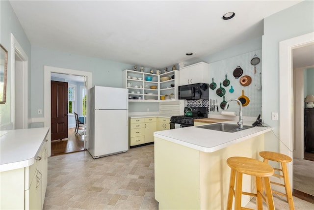125 Sakonnet Point Rd, Little Compton, RI 02837 - kitchen featuring black appliances, a sink, a peninsula, open shelves, and light countertops