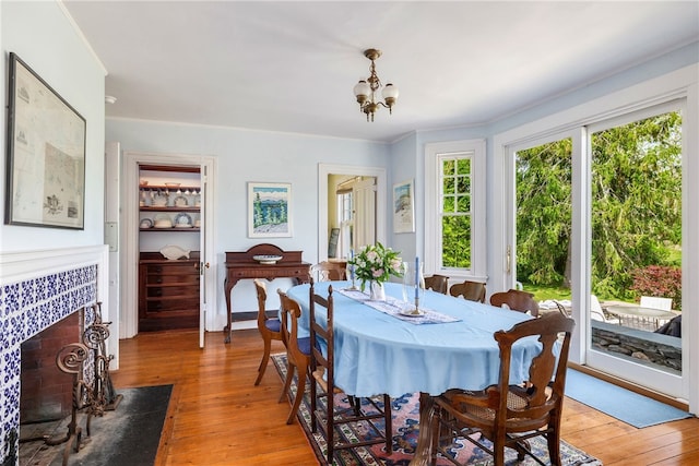 125 Sakonnet Point Rd, Little Compton, RI 02837 - dining room with light wood finished floors, a chandelier, and a tile fireplace