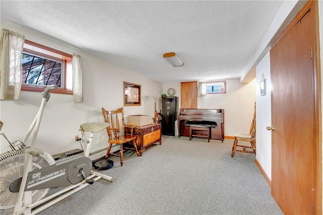 living area with a textured ceiling, light colored carpet, baseboard heating, and baseboards