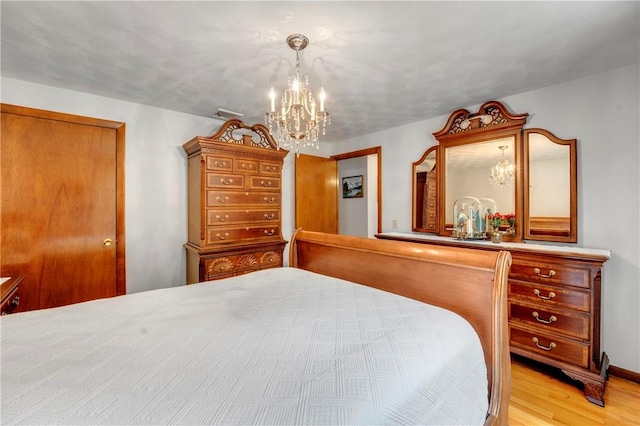 bedroom with a chandelier and wood finished floors