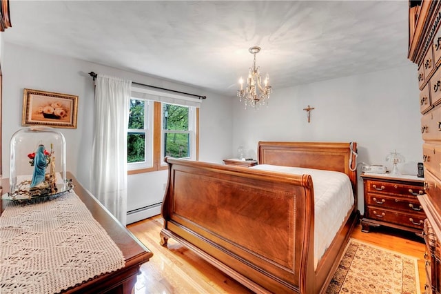 bedroom featuring baseboard heating, light wood finished floors, and a chandelier