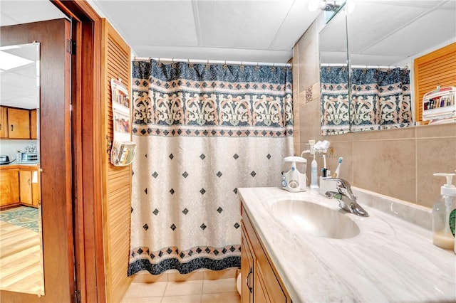full bathroom featuring vanity, tile patterned floors, tile walls, and a shower with curtain