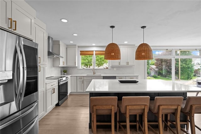 96 Roger Williams Dr, North Kingstown, RI 02852 - kitchen with stainless steel appliances, wall chimney exhaust hood, a sink, a breakfast bar, and recessed lighting