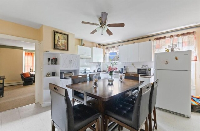 97 Detroit Ave, Providence, RI 02907 - kitchen featuring freestanding refrigerator, stainless steel microwave, stove, a baseboard radiator, and under cabinet range hood