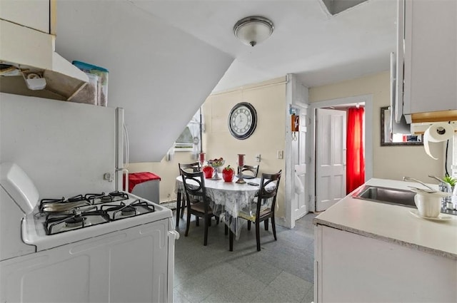 97 Detroit Ave, Providence, RI 02907 - kitchen with white appliances, light countertops, vaulted ceiling, and light floors