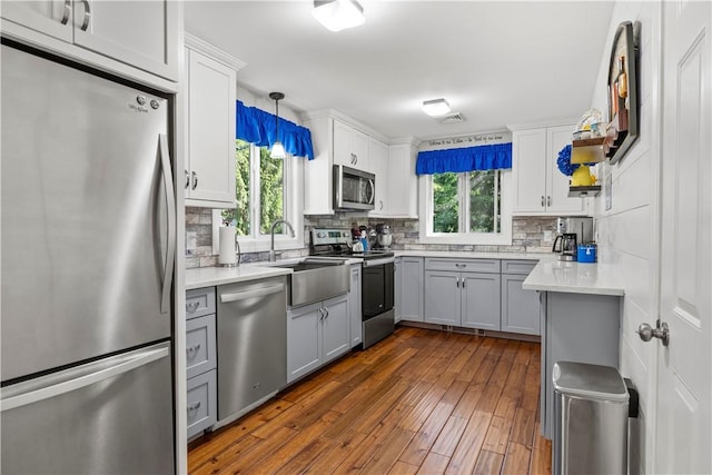 539 Allen Ave, South Kingstown, RI 02879 - kitchen with appliances with stainless steel finishes, backsplash, gray cabinetry, dark wood finished floors, and a sink