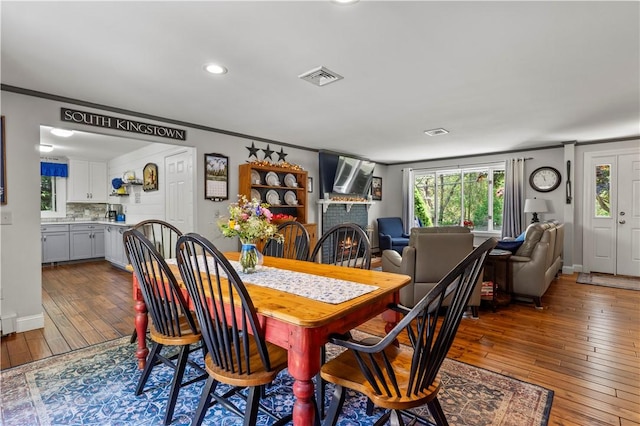 539 Allen Ave, South Kingstown, RI 02879 - dining space featuring wood-type flooring, crown molding, a fireplace, recessed lighting, and baseboards