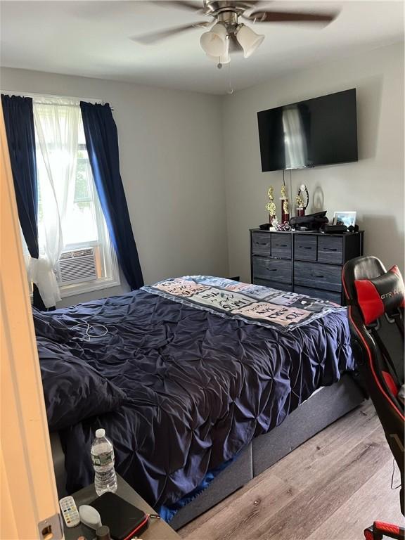 79 Dewey St, Woonsocket, RI 02895 - bedroom with wood finished floors, a ceiling fan, and cooling unit