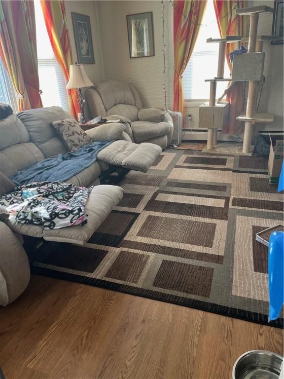 79 Dewey St, Woonsocket, RI 02895 - living room featuring wood finished floors, healthy amount of natural light, and a baseboard radiator
