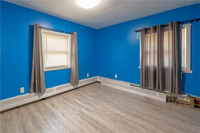 spare room with wood finished floors and baseboards