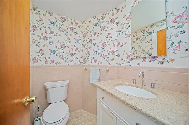 10 Meadowland Dr, North Kingstown, RI 02852 - half bath with wallpapered walls, tile walls, vanity, toilet, and a wainscoted wall