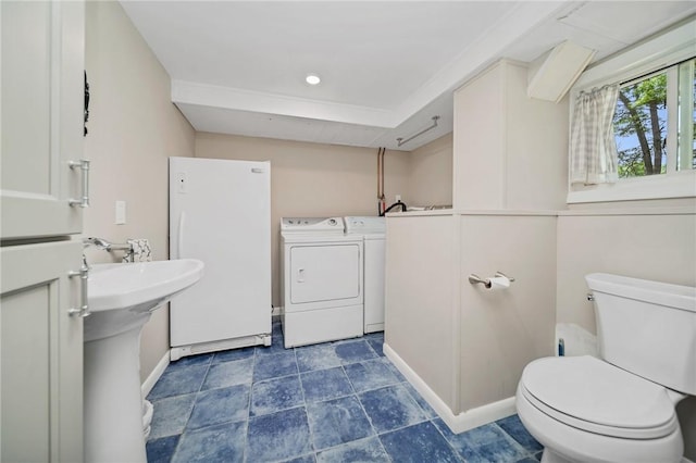10 Meadowland Dr, North Kingstown, RI 02852 - bathroom with washing machine and dryer, toilet, and baseboards
