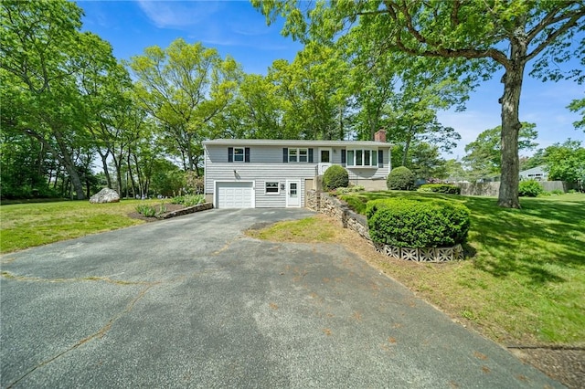 10 Meadowland Dr, North Kingstown, RI 02852 - view of front of home with a chimney, asphalt driveway, a front lawn, and an attached garage