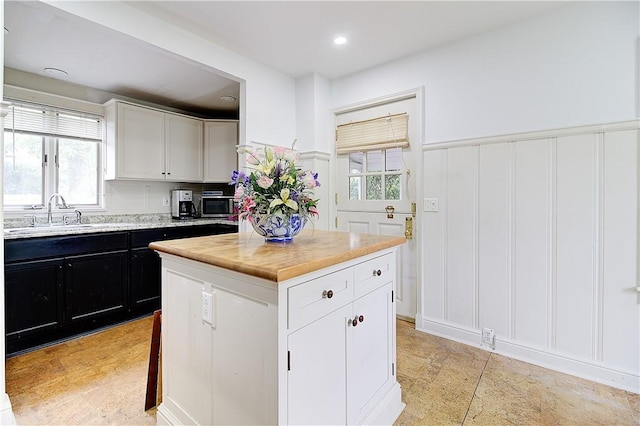 222 Second St, East Providence, RI 02865 - kitchen featuring a decorative wall, a sink, light countertops, dark cabinetry, and healthy amount of natural light