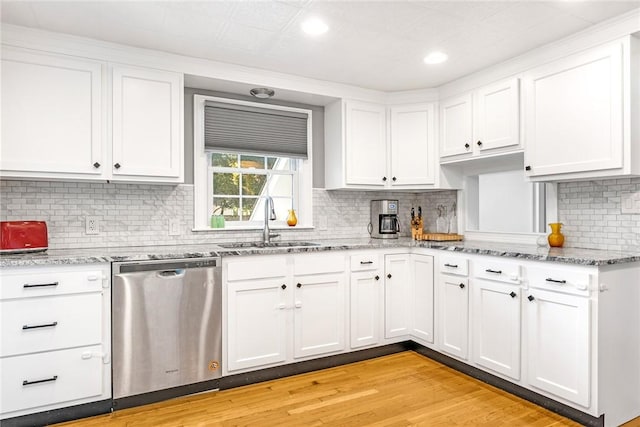 7 Massasoit Ave, Pawtucket, RI 02861 - kitchen with stainless steel dishwasher, a sink, white cabinetry, light wood-style floors, and backsplash