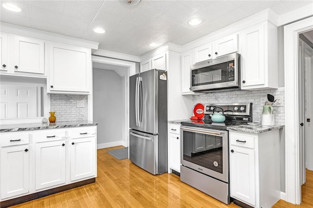 7 Massasoit Ave, Pawtucket, RI 02861 - kitchen featuring stainless steel appliances, white cabinetry, light wood finished floors, decorative backsplash, and light stone counters
