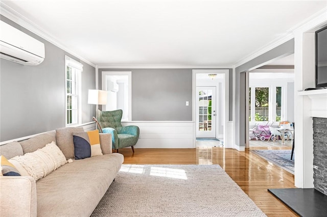 7 Massasoit Ave, Pawtucket, RI 02861 - living room featuring a wall unit AC, wood finished floors, a fireplace, crown molding, and a wainscoted wall