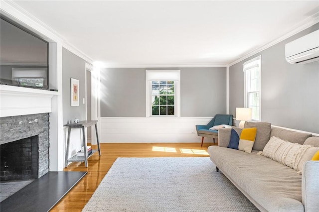 7 Massasoit Ave, Pawtucket, RI 02861 - living area with wood finished floors, a wall mounted AC, crown molding, a stone fireplace, and a wainscoted wall