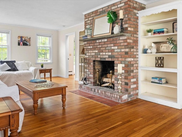 living area with crown molding, wood-type flooring, plenty of natural light, baseboard heating, and a brick fireplace