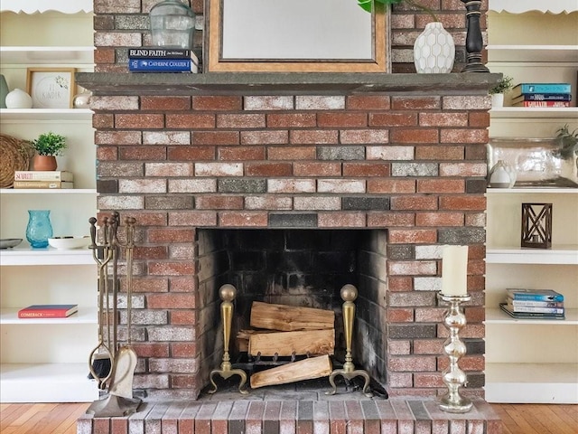detailed view of a brick fireplace and wood finished floors