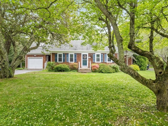 view of front of house with asphalt driveway, a garage, a front lawn, and brick siding