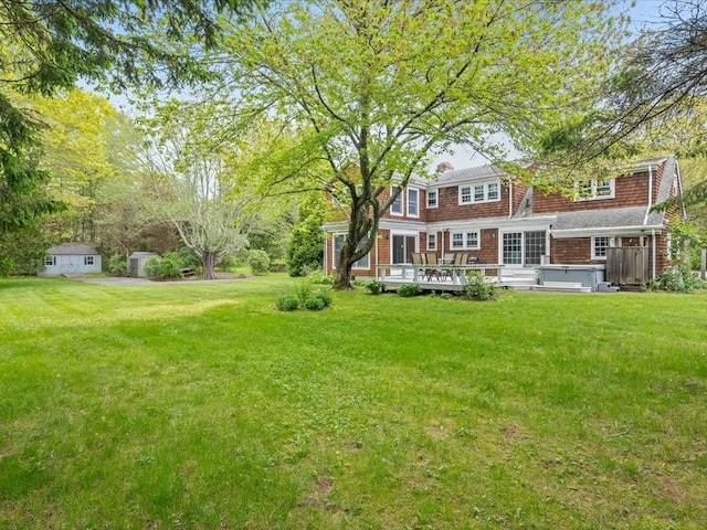 view of green lawn featuring a hot tub and a wooden deck