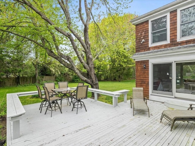wooden terrace featuring outdoor dining area and view of scattered trees